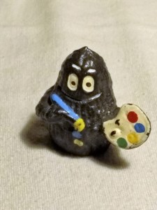 Schwarze Barbapapa-Figur mit Pinsel und Farbpalette in den Händen