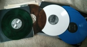 Bunte Schallplatten. eine in Grün, eine bräunlich, eine weiß und zwei in Blau