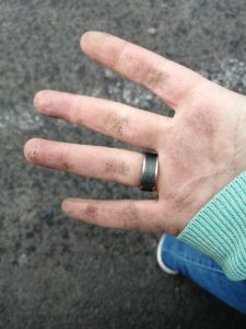 Dreckige Hand nach Graben in der Erde.