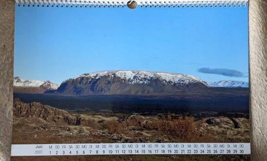 Juni Ein schneebedeckter Inselberg in einer braunen Ebene Blick von Þingvellir aus.
