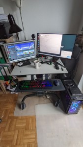 Kleiner Schreibtisch mit PC und zwei funktionierenden Monitoren