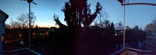 Panoramabild vom Sonnernuntergang vom Balkon aus, mit Baum im Mittelpunkt