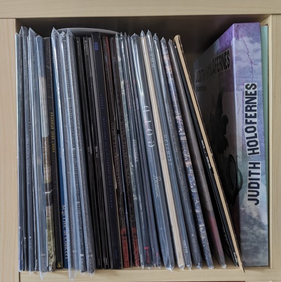 Ein Regalfach fast voll mit Vinyl-Schallplatten, teilweise in Schutzhüllen. Von links nach rechts: Musik aus Island, Skandinavien, Norwegen, Schweden, Niederlande, Mexiko, Japan und Deutschland