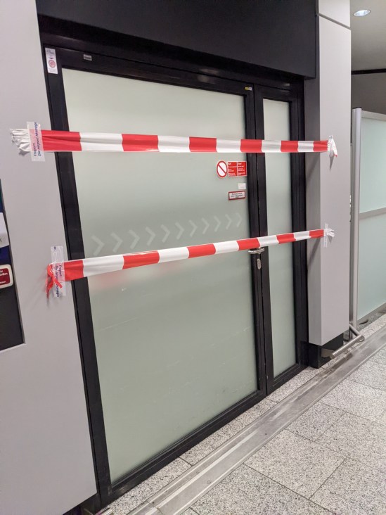 Tür mit zwei rot-weißem Absperrbändern versperrt