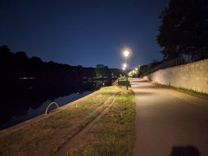 breiter Fuß- und Fahrradweg an der Spree, beleuchtet von Straßenlaternen
