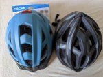 Zwei Fahrradhelme, einer bläulich, einer schwarz-silber