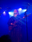 Elinborg mit schwarzer Gitarre vor einem Micro