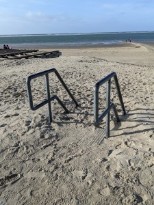Zwei Treppengeländer (rechts und links) verschwinden nach unten im Sand