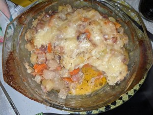 Kartoffel-Kohlrabi-Gratinversuch in Glasschüssel, mit Käse überbacken Allerdings ist hier der Käse nicht so braun, dafür gibt es braungebrannte Käserückstände an den Griffen das Ergebnis MIT Deckel Es ist etwas Flüssigkeit in der Schüssel zu sehen.