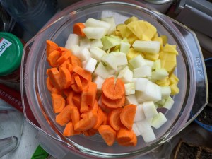 Glasschüssel mit klein geschnittenen Karotten-, Kohlrabi- und Kartoffelstücken