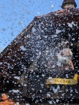 Man erkennt eine Frau Holle-Figur, die wohl gerade die Betten ausschüttelt, denn das ganze Foto ist voller weißer Flocken.