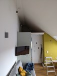 Raum mit Dachschräge. Über dem Eingangsbereich ist eine Verlängerung des Raumes unter der Dachschräge zu erkennen.