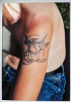 Tattoo eines Trolls mit Mütze auf dem Oberarm eines Kollegen