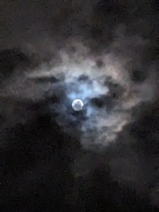 Vollmond hinter und durch Wolken