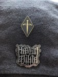 Zwei Pins an meiner Umhängetasche Einmal ein Dolch, bei dem die Parierstange ein W & W bilden. Das zweite ist Kælan Mikla in verschnörkelter Schrift.