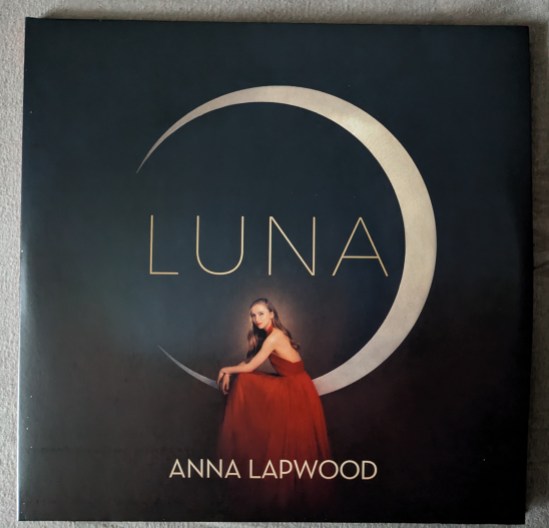 Cover der Pkatte LUNA mit Anna Lapwood Anna sitzt in einem roten Kleid auf der Mondsichel