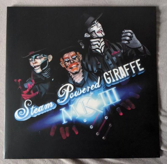 Cover der LP Steam Powered Giraffe MKIII zu sehen sind die drei Mitglieder der Band in ihren Steampunk-Roboter-Bemalungen