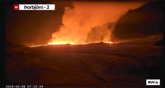 Bildschirmfoto der Eruption vom 08.02.2024 Livestream von RÚV. Unten links steht 2024-02-08 07:15:34 Oben links im Eck steht die Standortangabe der Kamera: Þorbjörn - 2 Es ist Nacht, der Himmel und der Vordergrund ist dunkel, doch es ist schneebedeckter Boden zu erkennen. In der Mitte des Bildes erstreckt sich der Feuerstreifen des aktuellen Ausbruchs. Eine große Rauchwolke erhebt sich über dem Eruptionsstreifen. Unten rechts steht RUV.is