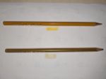 Zwei Buntstifte. Der obere sieht aus wie Ocker, darunter ist ein leuchtender gelber/goldener Fleck mit diesem Stift gemalt. Der untere Stift sieht aus wie Gold, die Farbe wirkt aber nicht leuchtend.