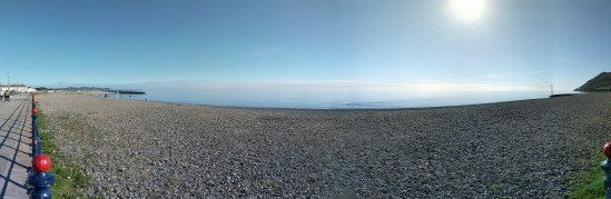 Die Irische See vom Strand von Bray aus gesehen. Strahlend blauer Himmel. Im Wasser ist die Spur eines Schwimmers zu sehen.