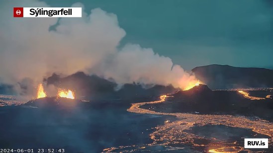 Bildschirmfoto der Eruption vom 29.05.2024 Livestream von RÚV. Unten links steht 2024-06-01 23:52:43 Oben links im Eck steht die Standortangabe der Kamera: Sýlingarfell Im der Bildmitte links ist eine kleine Kratererhöhung zu erkennen, hinter der Lava emporschießt. Rechts ist eine größere Kratererhöhung, in der ebenfalls Lavazu sehen ist und eine große Rauch/Dampfwolke, die von der Lasva dort ausgeht und nach links getrieben wird. Zwischen den beiden Kratern ist ein leuchtender Lavastrom zu sehen, der bin in den Vordergrund reicht und ebenfalls im Hintergrund zu sehen ist. Der Himmel ist zwischen Abenddämmerung und Nacht. Unten rechts steht RUV.is