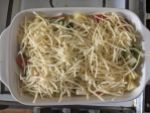 Gefüllte Auflaufform mit Käse überstreut