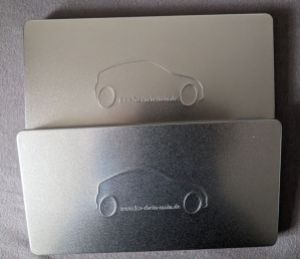 Zwei silberne Blechdosen, mit einem stilisierten Auto und dem Aufdruck www.fsz-rhein-main.de als Fahrzeugboden.