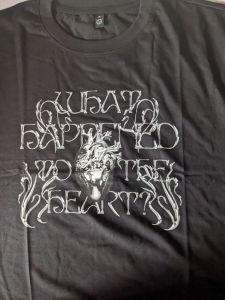 Schwarzes T-Shirt mit einer Art silbernem Metallherz in der Mitte, eingebettet in den Titel WHAT HAPPEND TO THE HEART?