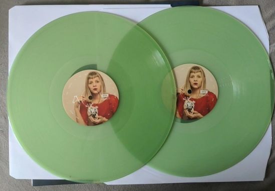 Beide Vinylplatten von AURORA in transparentem Grün/Jade. In der Mitte der Platten ist ein Bild von Aurora mit einem silbernem Herz in der Hand.