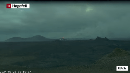 Bildschirmfoto der Eruption vom 22.08.2024 Livestream von RÚV. Unten links steht 2024-08-23 06:16:27 Oben links im Eck steht die Standortangabe der Kamera: Hagafell In der Bildmitte ist noch ein kleinesbisschen Feuerschein der Eruption zu erkennen. Rechts davon ist einer der Krater von einer der vorherigen Eruptionen zu sehen. Der Himmel ist trübe und bewölkt. Unten rechts steht RUV.is