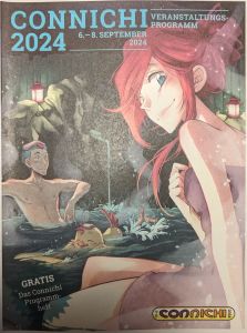 Titelbild des CONNICHI 2023 Veranstaltungsprogramms vom 6.-8- September 2024 Ein gezeichneter Mann im Anime-Comic-Style sitzt in einer Art Japanischem Naturbad. Auf seinen kurzen blauen Haaren liegt das kleine Tuch, welches in einem Onsen üblich ist. Vor ihm im Wasser planscht ein gelber Vogel, der ebenfalls das Tuch auf dem Kopf trägt, und rechts im Vordergrund sitzt eine gezeichnete Frau mit hochgesteckten roten Haaren und in ein Handtuch gehüllt, die mit blauen Augen den Betrachter des Bildes ansieht. Die Szenerie wird durch zwei Laternen links und rechts erleuchtet. Unten links steht noch: GRATIS Das Connichi Programmheft