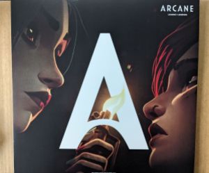 Cover des Arcane-Soundtracks von Season 1. Ein großes A im Bildmittelpunkt, links davon das Gesicht von Jinx, die ein Feuerzeug hält und zu Vis Gesicht rechts herunterschaut