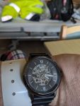 Blick auf die Armbanduhr, Uhrzeit 16 Uhr 17 Minuten. Im unscharfen Hintergrund ist ein Bett zu sehen, auf dem meine gelbe Arbeitsjacke und mein Rucksack zu erkennen ist.