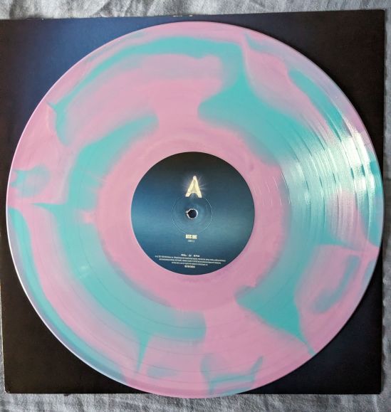 Vinyl-Scheibe des Soundtracks zur Serie ARCANE Die Scheibe ist blau-rosa gefleckt.