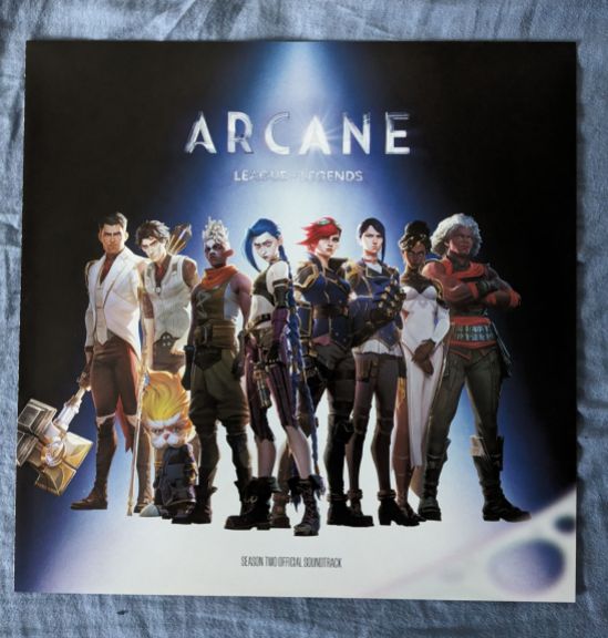 Innencover zum ARCANE Sewason Two-Soundtrack Zu sehen sind von links nach rechts Jayce mit Hammer, Victor, Heimerdinger, Ekko, Jinx, Vi, Caitlyn, Mel und Ambessa