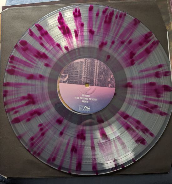 Vinyl-Scheibe des Albums NOWHERE NOW HERE der Band MONO Das Vinyl ist Pink-Transparent gefleckt, wie Spritzer vom Pink