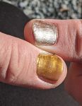 Ein golden und ein silbern lackierter Daumennagel