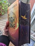 Buch mit Farbschnitt (einem fliegenden goldenen Drachen über Gewitterwolken) Das Buch ist das Hardcover von Iron Flame - Flammengeküsst von Rebecca Yarros.