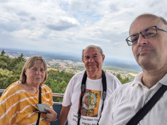 Meine Mutter, mein Vater-vor-Ort und ich auf einem Selfie vom Hahnekammturm. Im Hintergrund sind die Schornsteine des Staudingers zu erkennen und die Mainebene mit Häusern mit Blick Richtung Taunus.