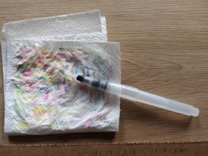 Wassertankpinsel auf Kreppapier mit bunten Flecken