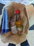 Lunchpaket in brauner Papiertüte mit Apfelschorle, Wrap und Sandwich