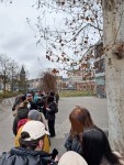 Immer noch eine lange Menschenschlange, rechts ist das Bockenheimer Depot zu sehen, wo die Schlange hingeht
